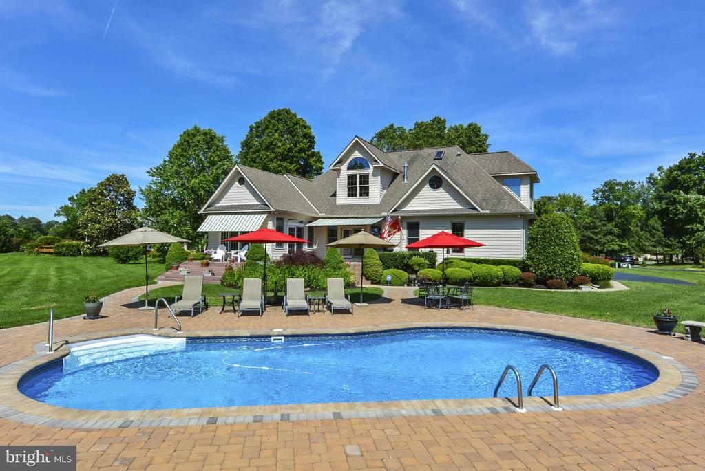Beautiful home w/pool and panoramic golf course views.  Gorgeous hardwood floors grace much of the main level.  Architecturally pleasing, the family room has vaulted ceilings, beautiful stacked stone gas FP and opens to large deck.   Main level Primary bedroom and large bath with walk in shower and soaking tub.  4th bedroom is currently used as a recreational room.   Living room is currently used as an office.  Large eat-in kitchen with island provides plenty of counter and cabinet space.  Separate Dining room.   Sun room overlooks  gorgeous backyard,  golf course and pool.   Maintenance free deck & gazebo.  In-ground salt water pool.