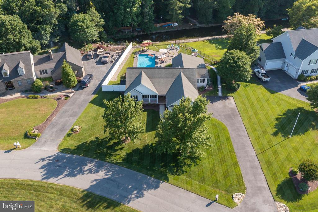 This waterfront custom-built ranch home situated on Red Mill Pond could be yours today! As soon as you walk through the front door you are going to fall in love with the custom shiplap trim, custom built-ins, and the solid hardwood floors that lead you from the spacious foyer to the great room. The great room features a cathedral ceiling, a gas fireplace with concrete mantel, a custom built-in bar area as well as a handcrafted barn door. The rich wood tones and white backdrop will have you feeling like you're in a real-life Pinterest post. The great room is immediately open to the dining area and the kitchen. The kitchen was completely remodeled in 2019 with custom cabinets with soft closed drawers and doors. The kitchen features a large island with a single slab quartz countertop, a Viking 36" range with 4 burners and a built-in griddle, a Viking range hood, Bosch dishwasher, island microwave, and a French door refrigerator.  Off of the kitchen is the laundry room, which contains the front load washer & dryer and custom built-ins as well. Around the corner from the kitchen is the sunroom and half bathroom and then the screen porch with the Eze-Breeze vinyl windows and the electric awning perfect for blocking the afternoon sun. Step outside from the screen porch and walk into your private oasis. The backyard has been carefully crafted and includes a large paver patio, EPHenry firepit, an 18' by 42' inground heated pool and super fun water slide, playset, and direct water access to Red Mill Pond. Red Mill Pond is the largest freshwater pond in the State of Delaware and motorized boats are permitted. You'll love the wooded backdrop from across the canal and the nature that you will find in the pond (fish, turtles, blue herons). You can even load up the built-in kayak rack with your very own kayaks, standup paddle boards, or canoes. Tucked away from the main living area you will find the owner's suite with its large walk-in closet and private ensuite. Enjoy a soak in the jacuzzi tub as well as the double vanity and separate walk-in shower. The two other guest bedrooms as well as the guest bathroom can be found at the end of the hallway.  As an added bonus, the attic, which is accessed from the oversized 2-car side entry garage, is monstrous. Saying that this is the quintessential beach home is an absolute understatement. The home features 43 (owned) solar panels making the electric bill minuscule! The garage houses the solar inverters as well as the water softener system and a 220-volt outlet so you can plug in your Tesla vehicle. You owe it to yourself to schedule your private tour right now! The owner is a licensed Delaware real estate agent.