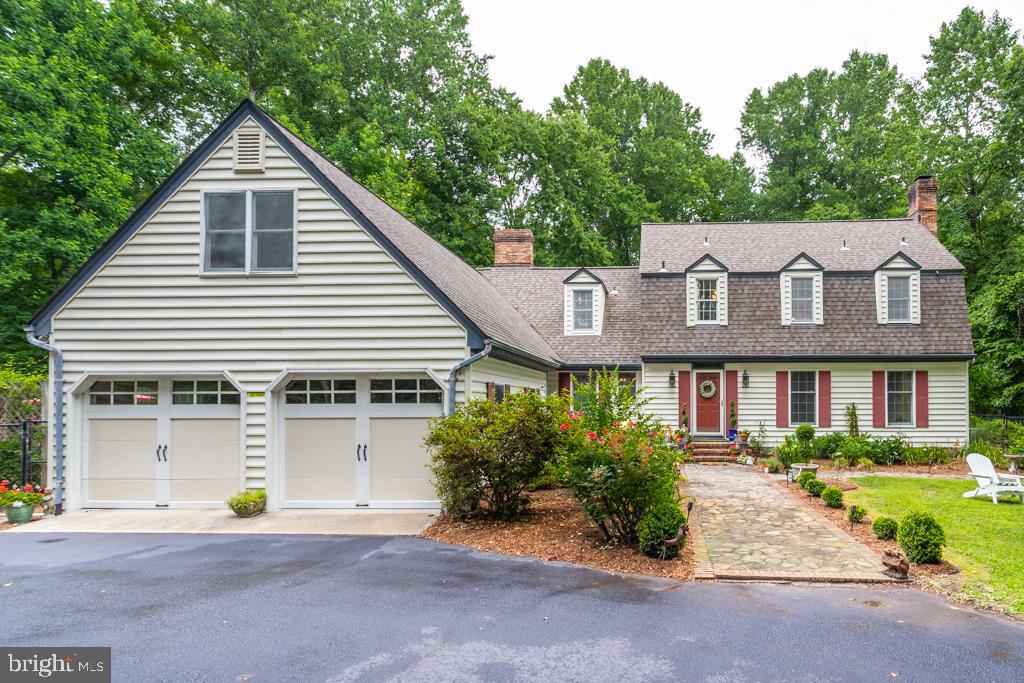 Dramatic entrance to gorgeously landscaped 4.78 acre property in sought-after Huntingfields Manor! No HOA, water-access community; Approx. 1 acre of this amazing property is fenced with 12 raised vegetable/flower beds; fruit trees (peach, apple, Asian pear); front entrance fish pond with waterfall; rustic trails through property’s woods, bounded by three creeks; community dock on Hunting Creek for kayaking/fishing; area's most sought-after school system. This home features a semi-detached au-pair/bedroom suite w/ built-in storage/closet space complete with upgraded bronze drawer pulls, new flooring, access to a full bathroom, and a rarely found, separate/private access staircase. The staircase leads from/to the garage and huge mud/laundry area where you'll notice coordinating built-in storage, tile floors, washer/dryer and counter space to fold laundry or store plenty of household items; dreamy kitchen has the finest touches with glowing cabinet underlighting, quartz counters, separated brick hearth w/ gas top cooking surface, high-end plumbing fixtures, bronze cabinet hardware, stainless steel appliances and more; dining room has hardwood flooring, built-in china closet/storage and matching hardware. Crown moulding and baseboard trim details are all upgraded, no detail has been spared. There is a fixed staircase attic access with much more storage area or potential for more finished space; large patio area with lush variety of plants, shrubs and privacy, perfect for a summer evening outdoors, storage cabinets throughout the home, two working fireplaces (wood and gas), three heat pump a/c units plus baseboard heat throughout; elegant living spaces and charming primary suite with sweeping views of the property on three sides; sun porch; several available spaces for inground pool; circular, asphalt driveway was recently sealed, water treatment system in place.  Full finished basement, perfect for home gym, with mirrored folding doors and ample additional storage space. This is a hidden retreat and homes like this haven't come around much in this market!