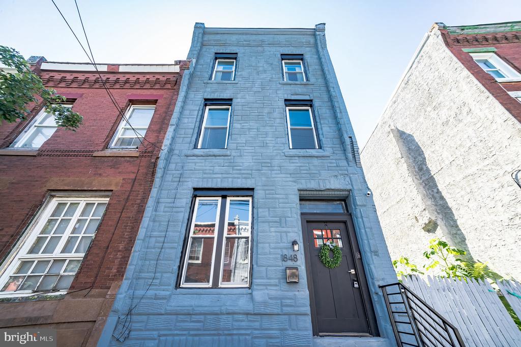 ONE YEAR HOME WARRANTY  included in the sale.  Welcome to 1848 N 27th Street, a newly  renovated 4 bed, 2-1/2 bath home in the quickly evolving Brewerytown neighborhood.   This area is booming with newly renovated homes and lots of new and exciting development.   Enter through the vestibule with new black and white hexagonal tile on the floor to capture the timeless essence of the home.  The charm and character is maintained throughout the home with the curved crown molding on the ceilings and wainscoting along the stairs.  The first floor is an open concept with new floors, living room, dining room, powder room and large kitchen with eat in peninsula.  The kitchen has white shaker cabinets, quartz counter tops, stainless steel appliances with hexagon carerra backsplash.    Off of the kitchen is a spacious private outdoor patio with a new concrete slab and wood slat fence.    Head upstairs where you will find three spacious bedrooms and a large bathroom with a bathtub, surrounded by white subway tile.  Up on the third floor, you will find the primary suite with an en suite full bathroom.   The bathroom has a large stand-up glass encased shower with decorative tile around and tile flooring.  New roof, water heater, plumbing, HVAC, ductwork, electrical panel/ wiring throughout and ONE YEAR HOME WARRANTY included.   
Currently Brewerytown is in the process of change. Though recent real estate growth has slowed, the community continues to repopulate and diversify. Between 1999 and 2006, over 200 new homes were developed in Brewerytown, as well as a technology and community center. The western portion of Girard Avenue is seeing a resurgence of businesses. Its proximity to Center City, the Philadelphia Zoo and the Philadelphia Art Museum makes it very desirable to renters and buyers. The prevalence of vacant land in the community provides opportunity for development of additional housing.