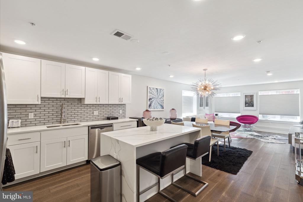 Welcome to this absolutely gorgeous and super sophisticated, bilevel, 3 bed/2 bath condo unit with PARKING!! This thoughtfully designed newer construction unit has designer finishes throughout including a luxurious kitchen with white shaker cabinets, Whirlpool stainless steel appliances, Calcutta quartz countertops, a two-sided waterfall island, a designer light fixture, and an ice-beveled subway backsplash. This sunlight unit also features automatic/motorized window shades on the first floor, a master suite with a giant closet outfitted with custom shelving, another designer light fixture, and a top-of-the-line porcelain tiled shower with frameless glass doors. The lower level features two additional bedrooms, an additional bathroom with a Kohler soaking tub and subway surround porcelain tile, and a spacious laundry room. The home features engineered smokey oak hardwood flooring. Enjoy all the comforts of modern technology with a keyless remote entry system, LED lights throughout, Nest Thermostats, and an ADT security and video surveillance system. This unit also has 7 years remaining on the tax abatement, a storage unit in the basement, and 1 car rear parking behind the unit. An absolute must-see! Close to tons of restaurants, shopping, the Parkway, Whole Foods, the Art Museum and so much more. Schedule your showing today!
